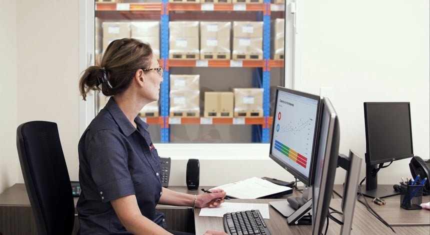 worker reviewing real-time order tracking and reporting for manufacturing and contract packaging
