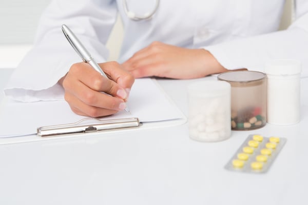 Vet writing on clipboard the prescriptions in medical office-1