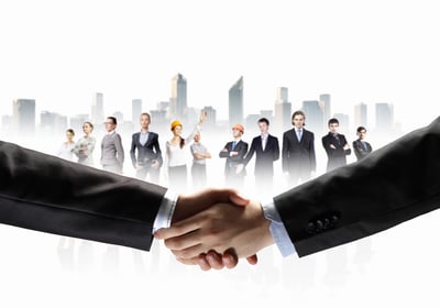 business handshake against white background and standing businesspeople