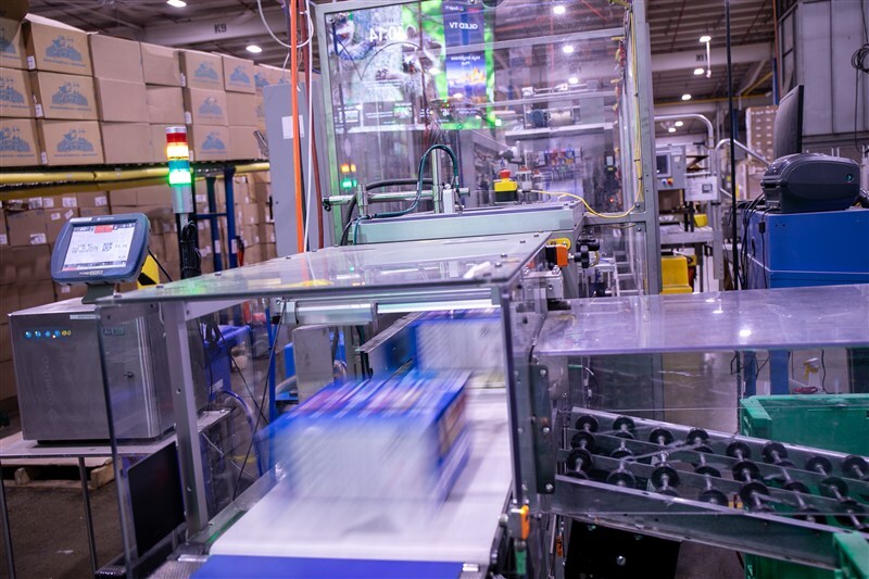 Side-by-side production line comparison showing dedicated high-volume automated line versus flexible short-run manual assembly station