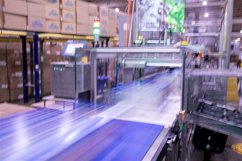 In-process quality check with photo documentation tablet at secondary packaging line with multipacks moving through checkweigher