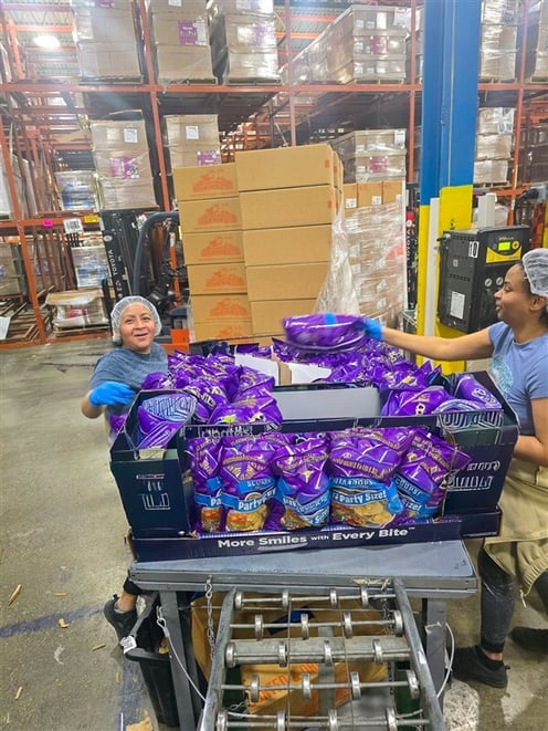 Engaged team of workers assembling retail-ready displays on production floor at Industrial Packaging