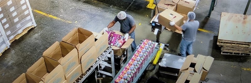 Industrial Packaging facility floor showing multipack or kit assembly operation with confectionery products and organized workflow