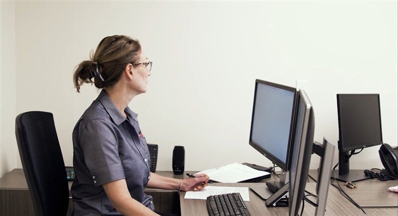 Team meeting at planning table with packaging samples, dyelines, and specifications being reviewed collaboratively